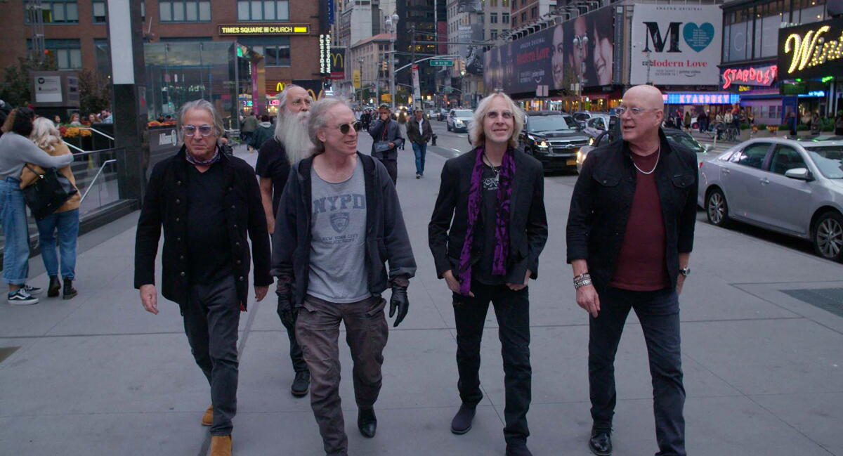 Five session musicians walk down a street