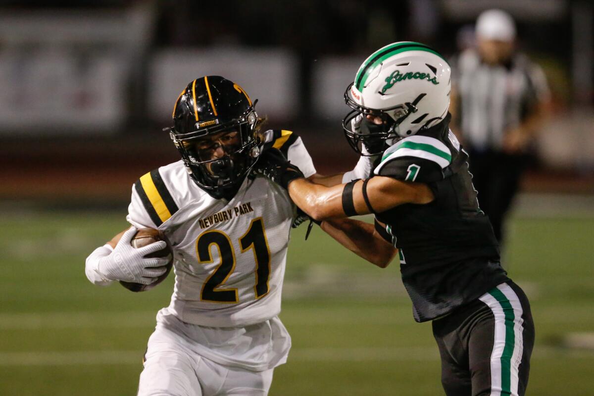 Newbury Park's Shane Rosenthal (21) tries to fend off Thousand Oaks' Johnny Abarzuan after making a catch.