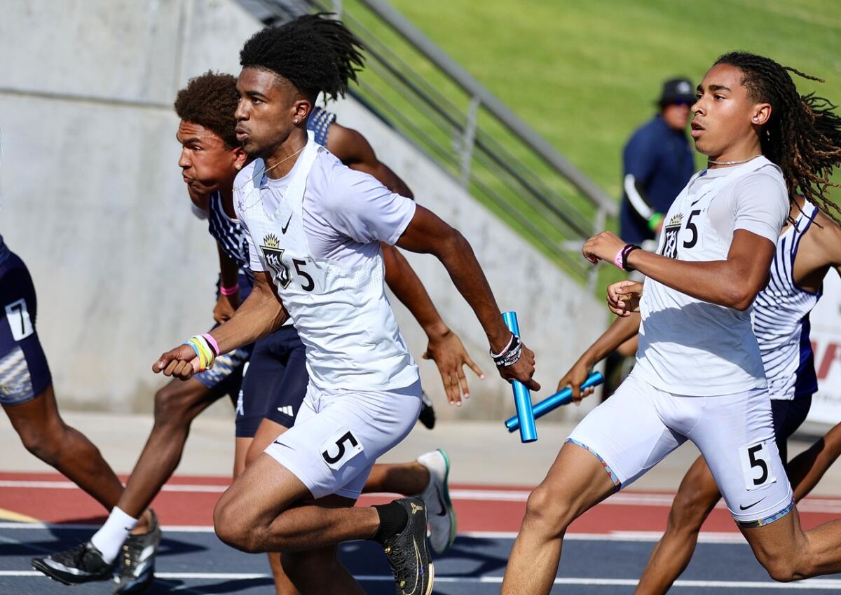Jace Wells slows up after passing the baton to Servite teammate Jaelen Hunter.