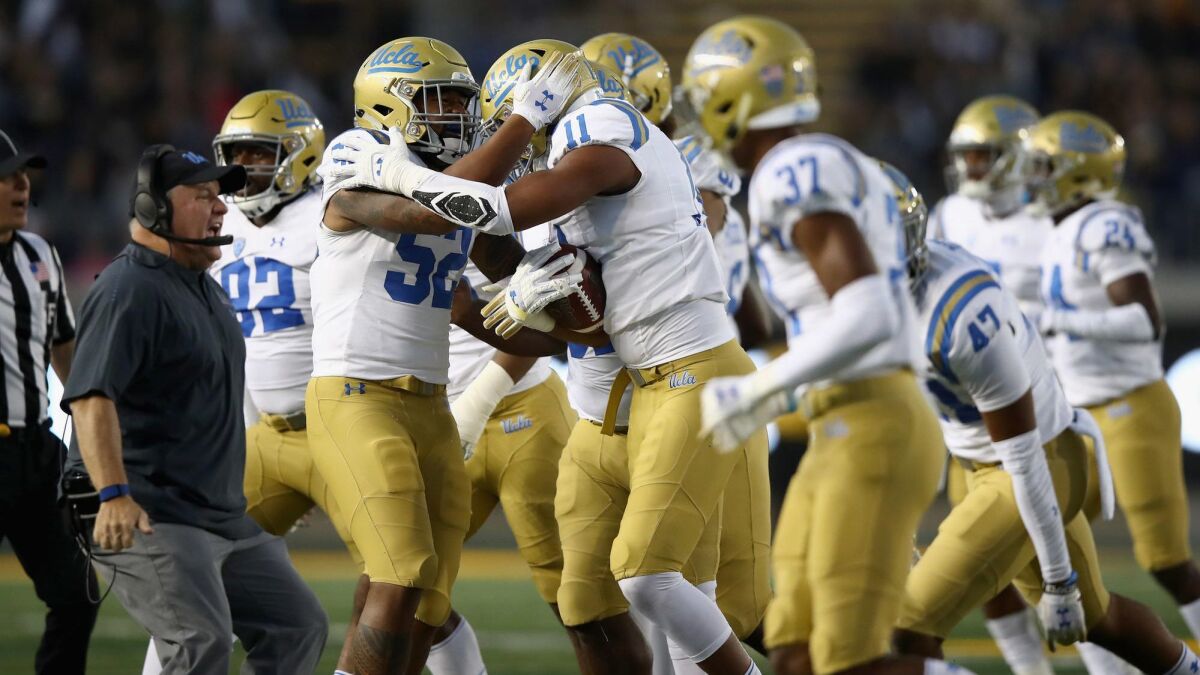 UCLA's Keisean Lucier-South (11) is congratulated by teammates and head coach Chip Kelly after he intercepted a pass against California at California Memorial Stadium on Oct. 13 in Berkeley.