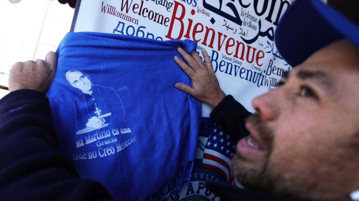 Oscar Levi Dominguez, 45, president and founder of El Salvador Corridor, holds a scarf with an image of Oscar Romero. The scarf carries a quote from Romero, "Martyrdom is a grace that I do not believe I deserve."