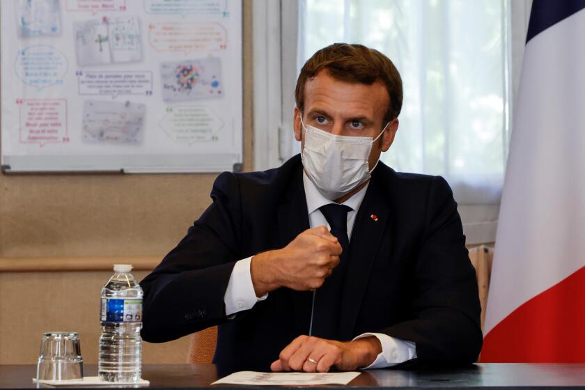 French President Emmanuel Macron chairs a meeting with the medical staff of the Rene Dubos hospital center, in Pontoise, outside Paris, Friday Oct. 23, 2020. French Prime Minister Jean Castex said Thursday a vast extension of the nightly curfew that is intended to curb the spiraling spread of the coronavirus, saying "the second wave is here." The curfew imposed in eight regions of France last week, including Paris and its suburbs, is being extended to 38 more regions and Polynesia, (Photo by Ludovic Marin, Pool via AP)