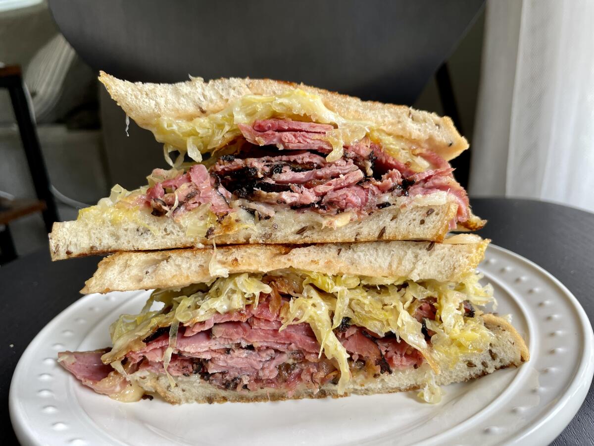 Two halves of a Reuben sandwich stacked 