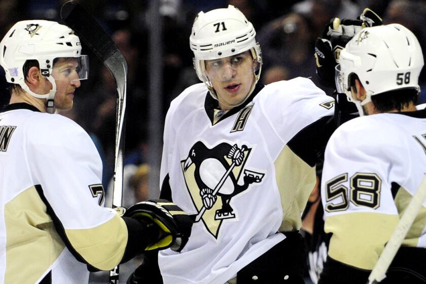 Penguins center Evgeni Malkin, center, is congratulated by defensemen Paul Martin (7) and Kris Letang (58) after scoring against the Sabres during a game Saturday night in Buffalo.