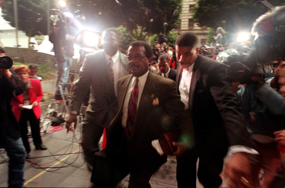 Johnnie Cochran is escorted to the courthouse by bodyguards from the Nation of Islam.