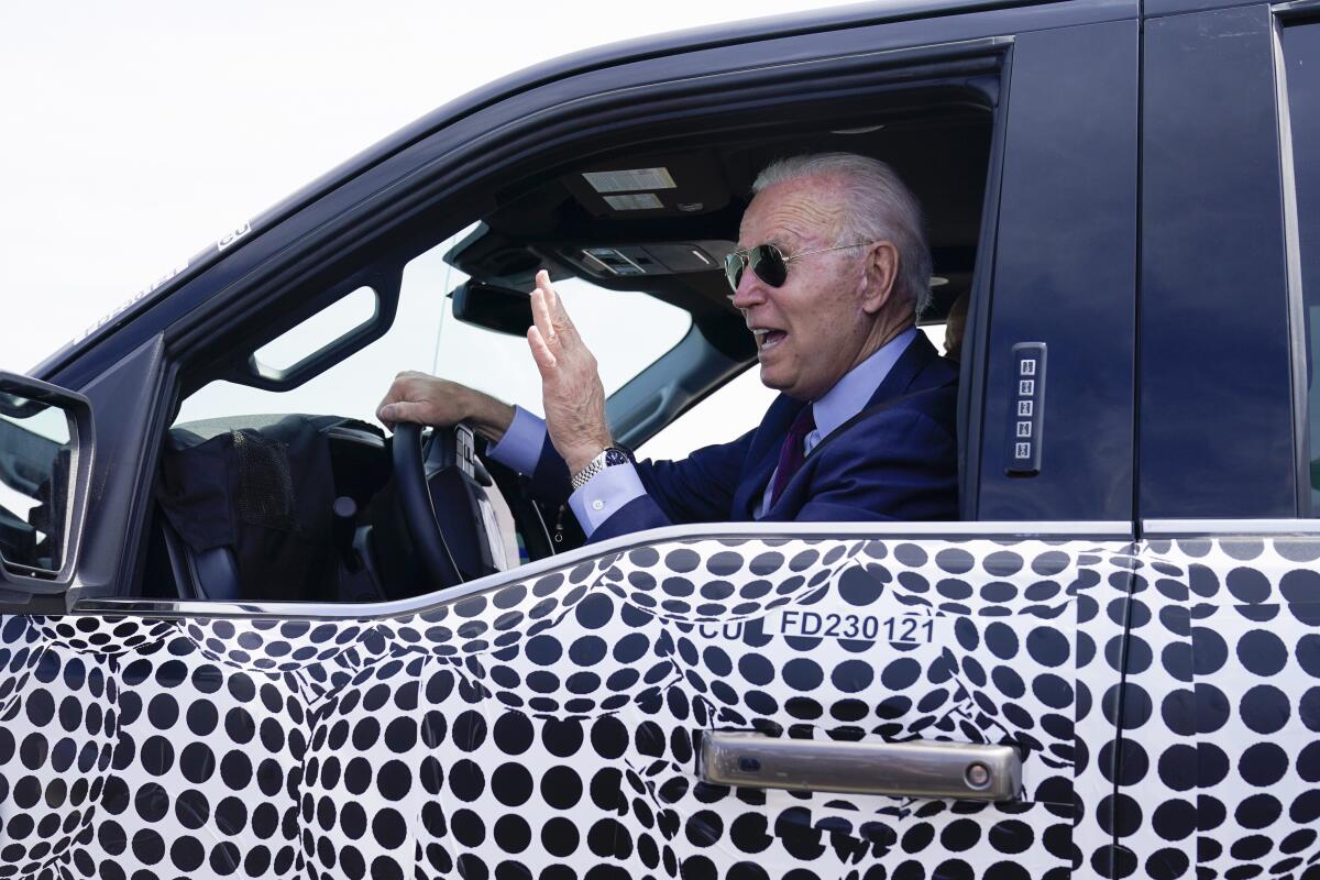 President Joe Biden stops to talk to the media as he drives a Ford F-150 Lightning truck at Ford Dearborn Development Center, Tuesday, May 18, 2021, in Dearborn, Mich. (AP Photo/Evan Vucci)
