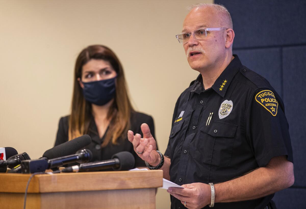 Tucson Police Chief Chris Magnus speaks as Mayor Regina Romero listens during a news conference.