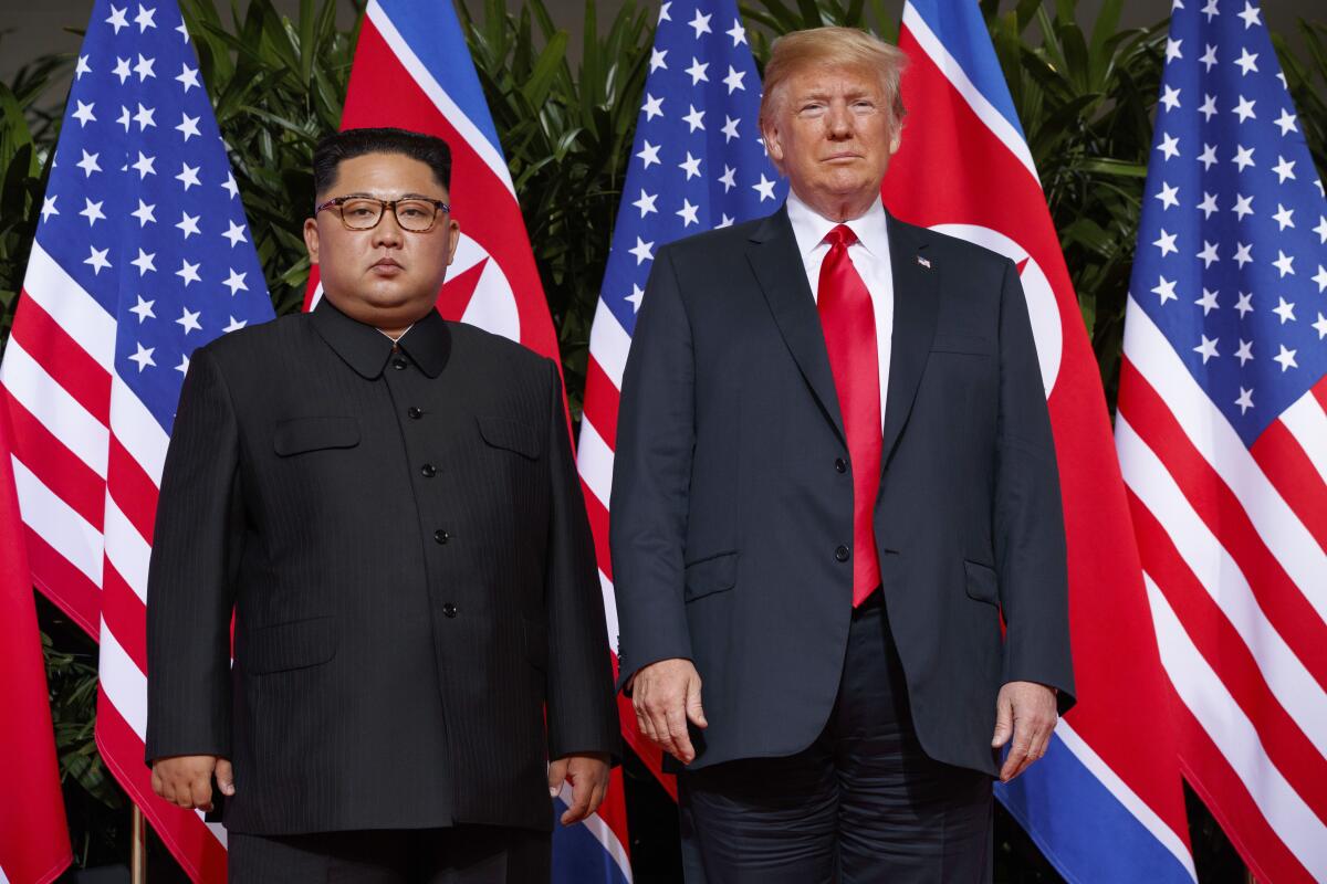 Kim Jong Un está de pie junto a Donald Trump.