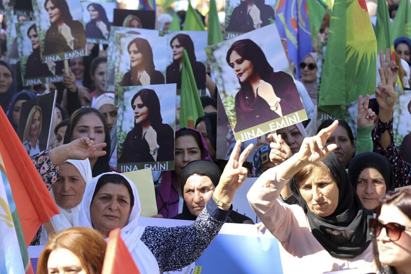 En esta foto proveída por la agencia kurda Hawar News Agency, mujeres kurdas llevan retratos de la iraní Mahsa Amini en una protesta por su asesinato en Irán, realizada en la ciudad iraquí de Qamishli el 26 de septiembre del 2022. (Hawar News Agency vía AP)
