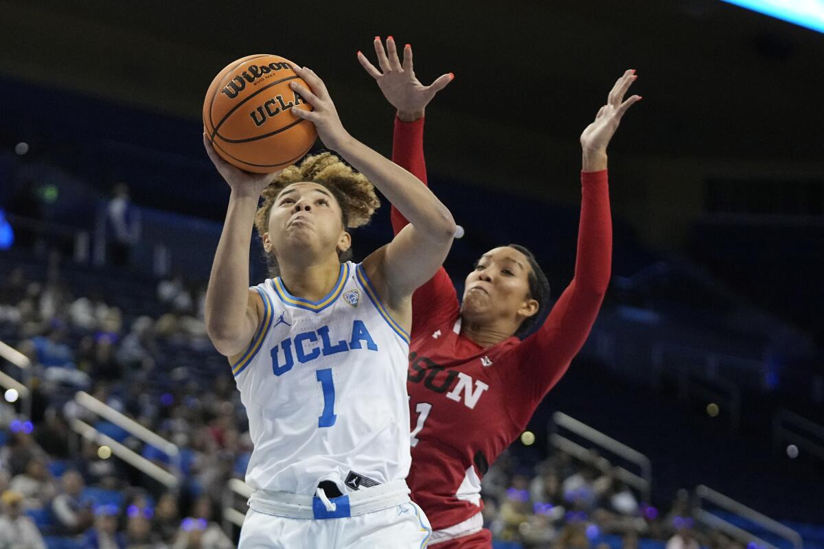 UCLA guard Kiki Rice, left, shoots in front Cal State Northridge forward Olivia Smith at Pauley Pavilion.