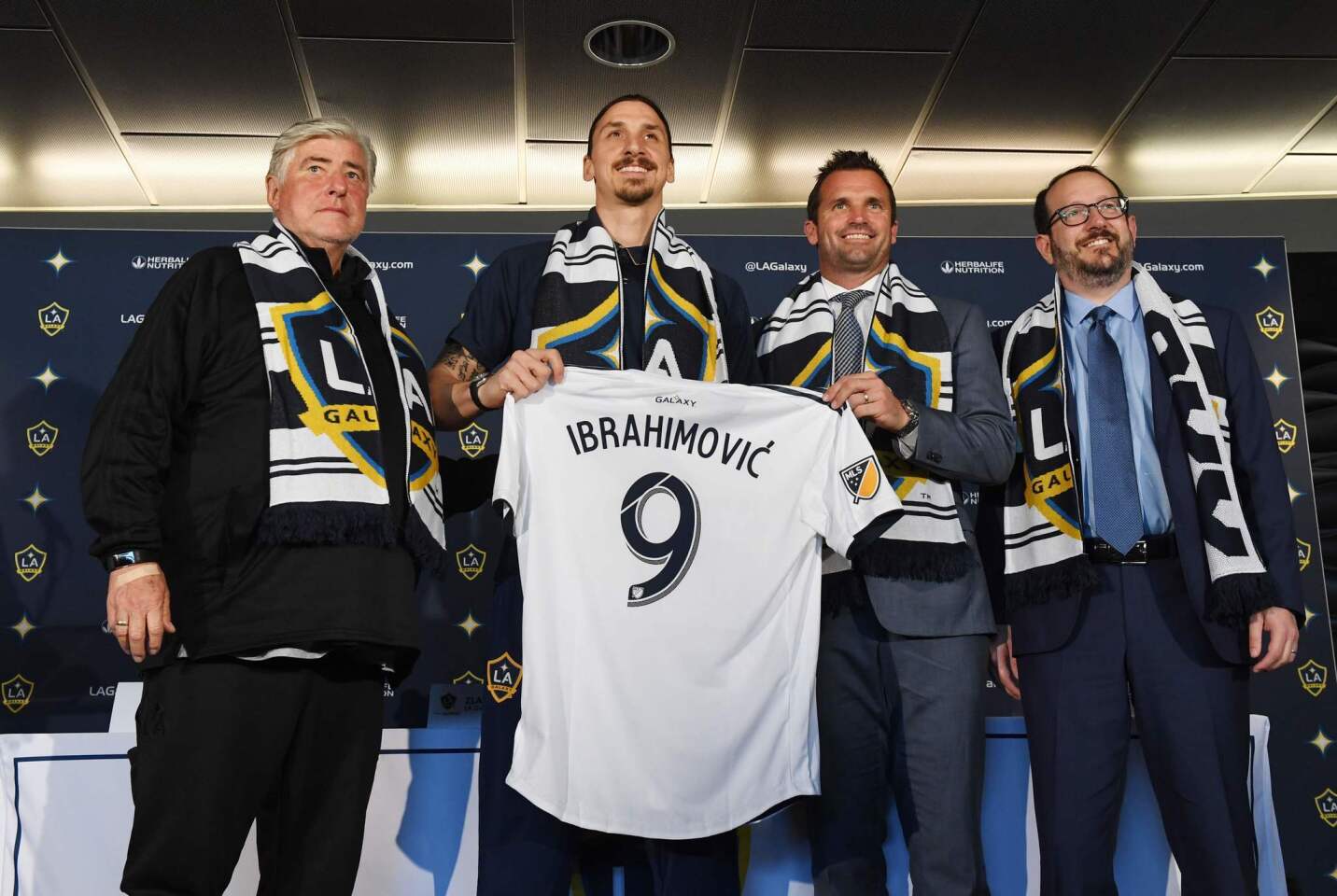 LA Galaxy footballer Zlatan Ibrahimovic (2L) holds up his new team jersey with coach Sigi Schmid (L), club president Chris Klein (2R) and AEG President Dan Beckerman (R) during a first press conference in Los Angeles, California, on March 30, 2018. The 36-year-old Swedish striker's move to MLS from Manchester United was confirmed last week, with Ibrahimovic swiftly vowing to reignite the Galaxy's fortunes after they finished bottom of the league last season. / AFP PHOTO / Mark RALSTONMARK RALSTON/AFP/Getty Images ** OUTS - ELSENT, FPG, CM - OUTS * NM, PH, VA if sourced by CT, LA or MoD **