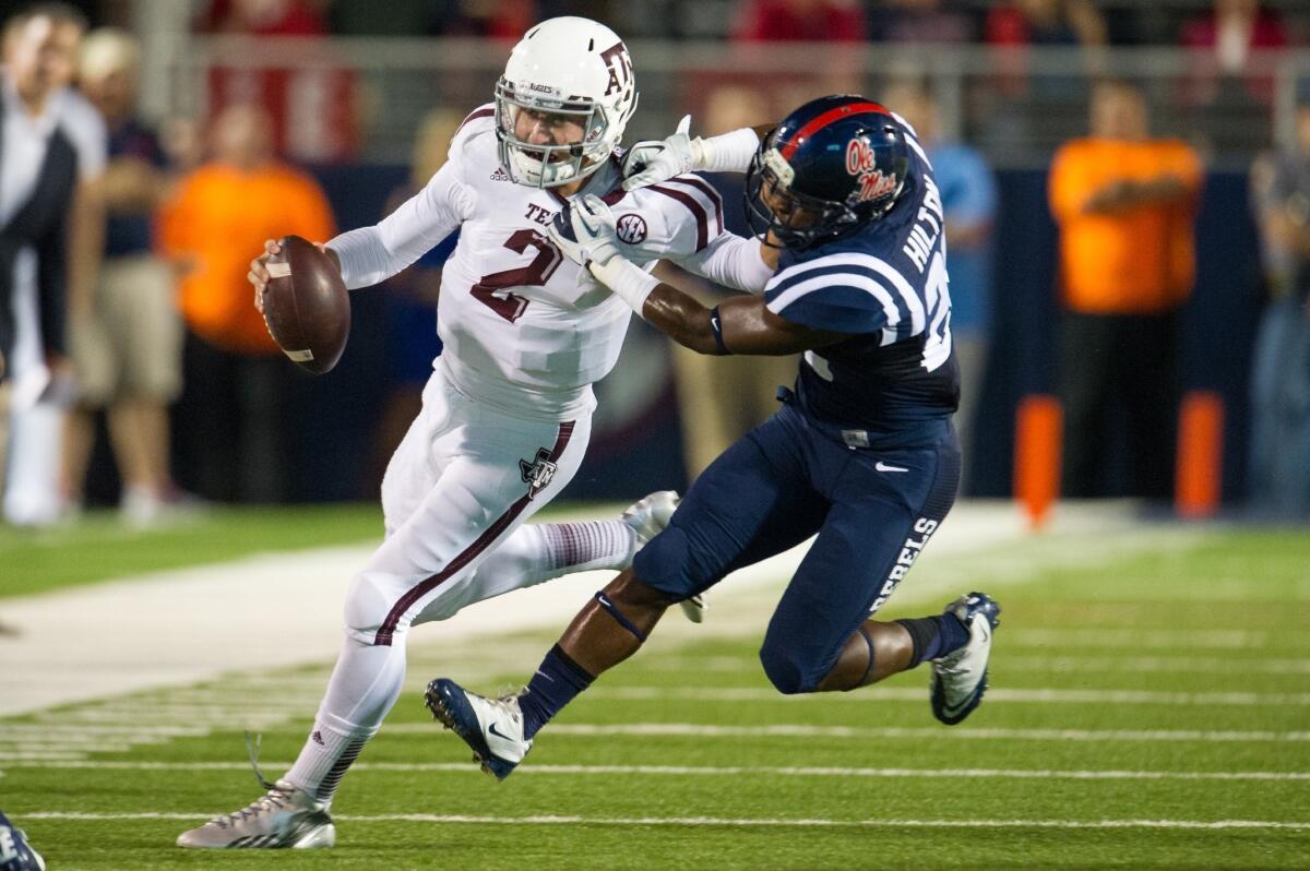 Texas A&M quarterback Johnny Manziel is collared by Mississippi defensive back Mike Hilton during a run Saturday.