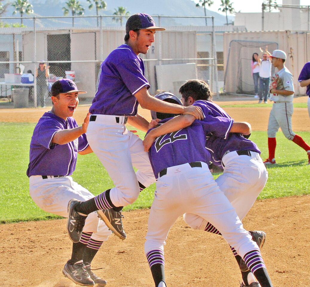 Hoover baseball players jump onto teammate Jonathan Ramos who layed down a bunt in the 8th inning to score a runner on third base to beat Burroughs in a Pacific League baseball game at Hoover High School in Glendale on Friday, May 2, 2014. Hoover won the game in the 8th inning 4-3.