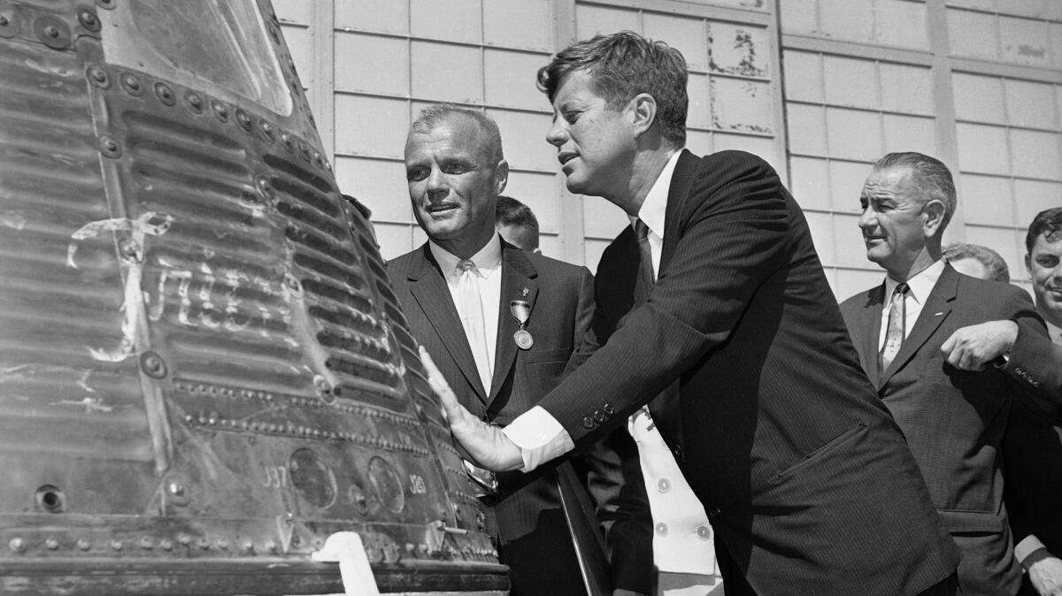 FILE - In this Feb. 23, 1962 file photo, astronaut John Glenn and President John F. Kennedy inspect the Friendship 7, the Mercury capsule in which Glenn became the first American to orbit the Earth. Kennedy presented Distinguished Service medal to Glenn at Cape Canaveral, Fla. At right is Vice President Lyndon Johnson. Glenn, who later spent 24 years representing Ohio in the Senate, has died at 95. (AP Photo/Vincent P. Connolly, File)