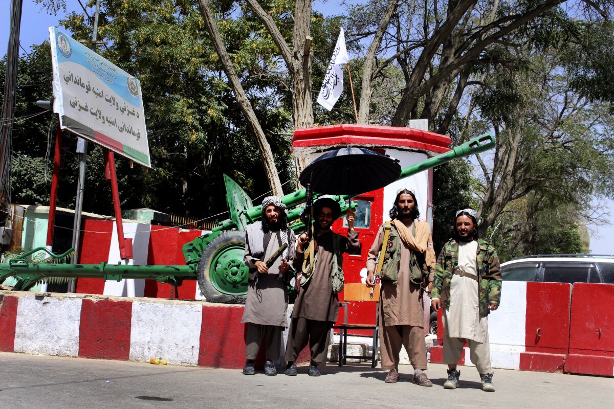 Taliban fighters pose with weapons