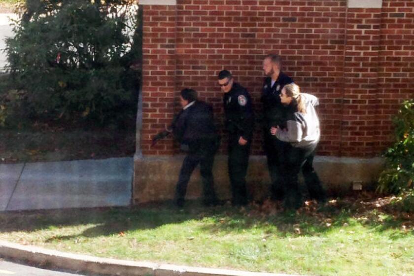 In this photo taken through a window and provided to the AP, which has been authenticated based on its contents and other AP reporting, police officers respond to a report of a suspicious person at Central Connecticut State University in New Britain, Conn.