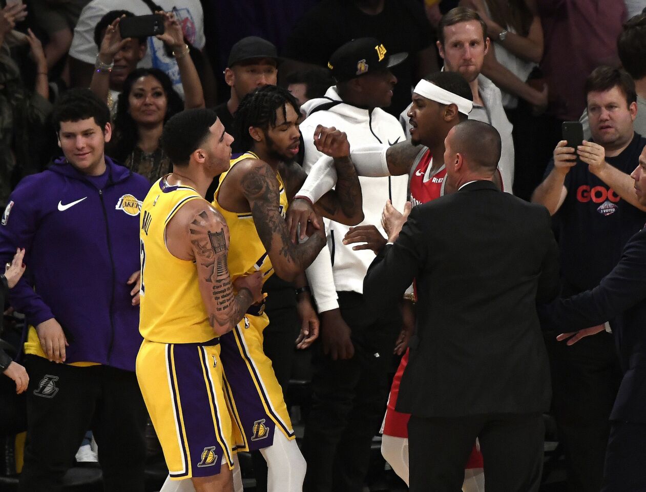 Lakers guard Lonzo Ball tries to separate teammate Brandon Ingram and Rockets forward Carmelo Anthony after Ingram ignited a brawl by shoving Rockets guard James Harden.