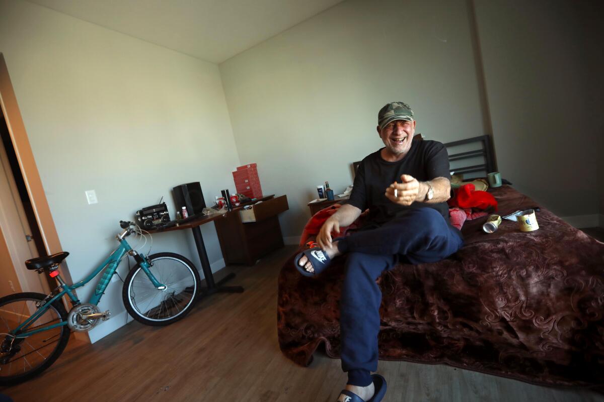 A man smiles in an apartment.