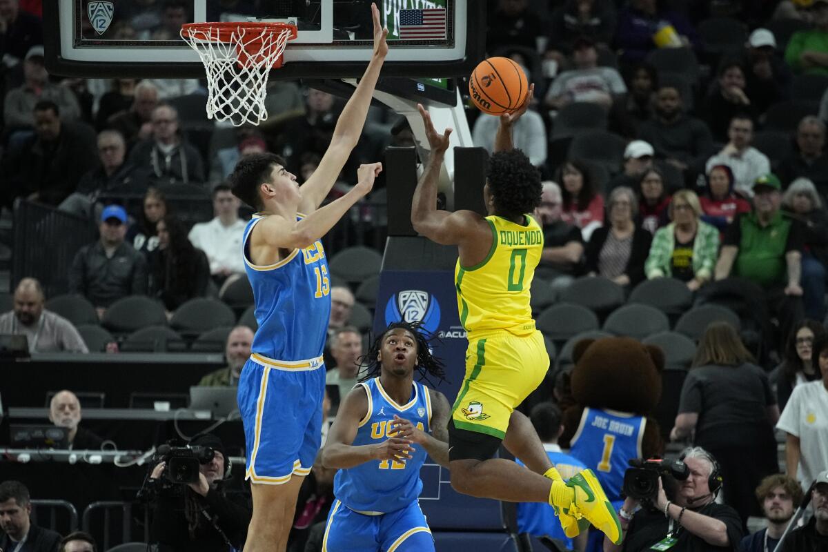 UCLA center Aday Mara, left, tries to block a shot by Oregon guard Kario Oquendo during the first half Thursday.