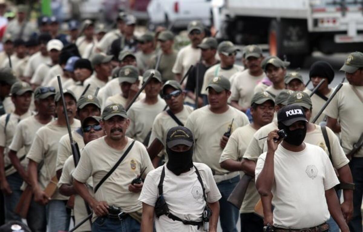 Community police members take part in the March for Justice and Dignity in the town of Ayutla de los Libres in Guerrero state on Saturday. Hundreds of armed civilians have begun providing security for communities in the state, creating a vigilante force.