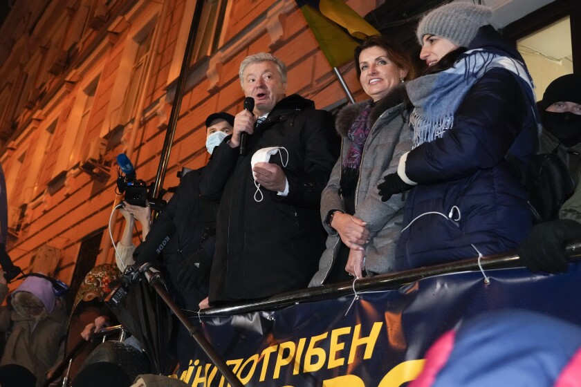 El expresidente ucraniano Petro Poroshenko se dirige a sus simpatizantes frente a un edificio de la corte el lunes 17 de enero de 2022, en Kiev, Ucrania. Junto a él se encuentra su esposa Maryna. (AP Foto/Efrem Lukatsky)