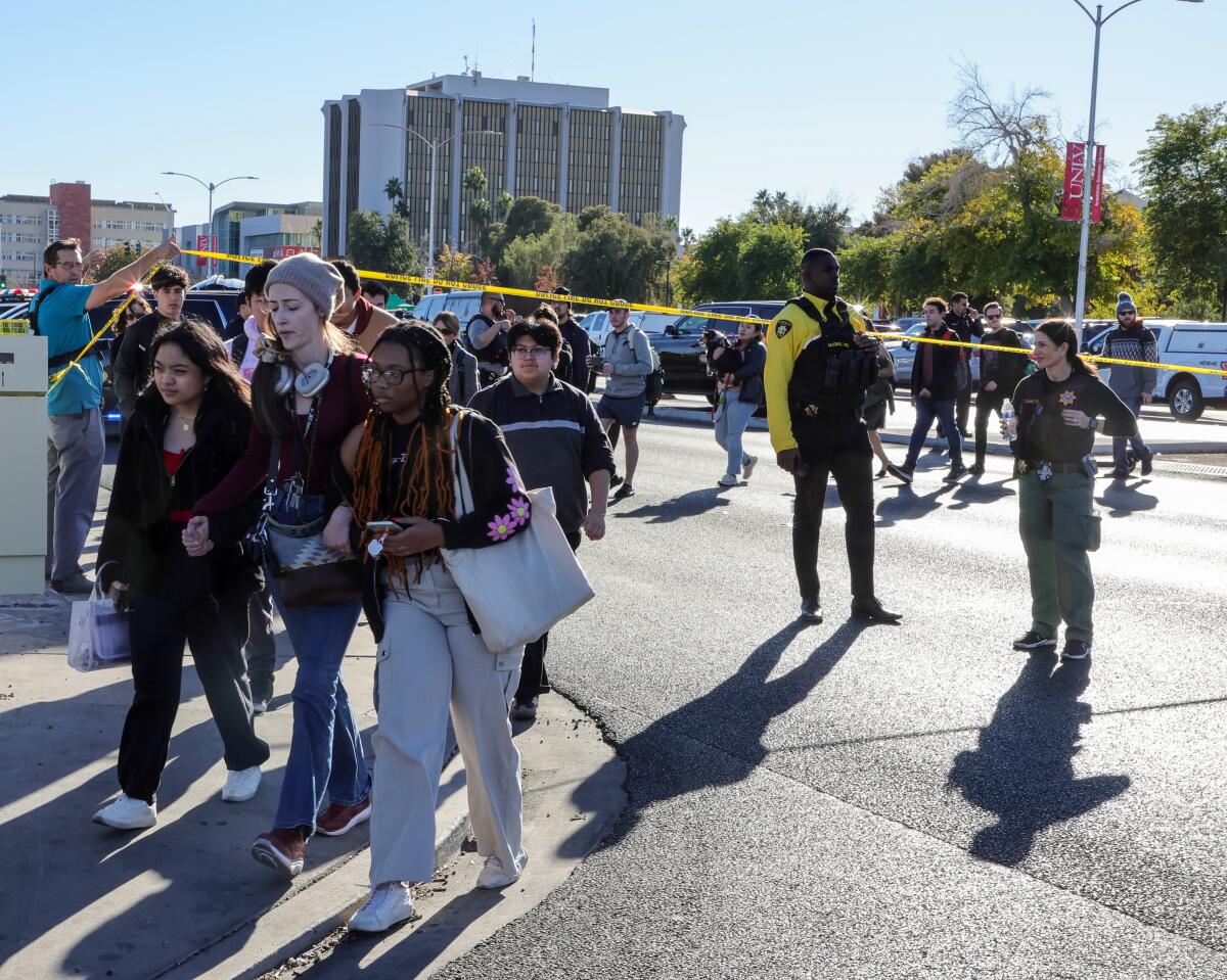  People cross Maryland Parkway as they are led off the UNLV campus.