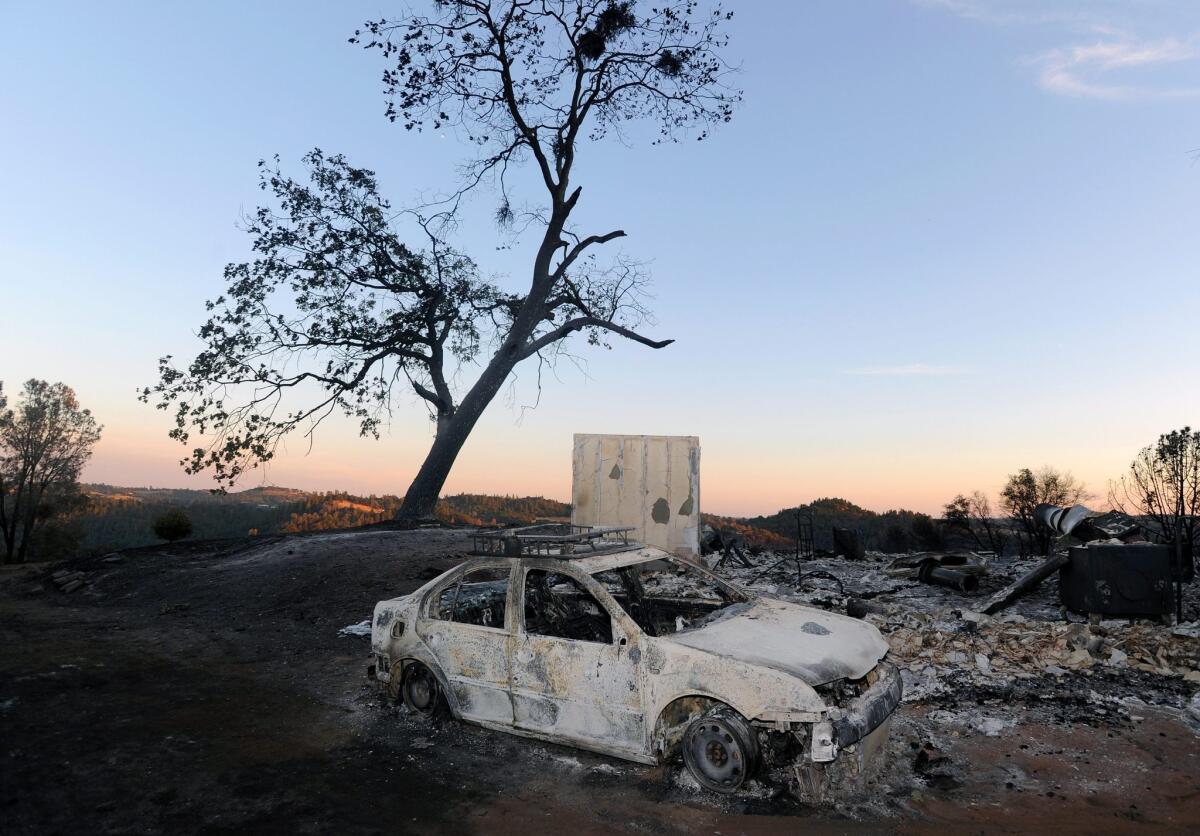 A burned out car sits near a home that was also destroyed in the Sand fire in Amador County in Northern California.