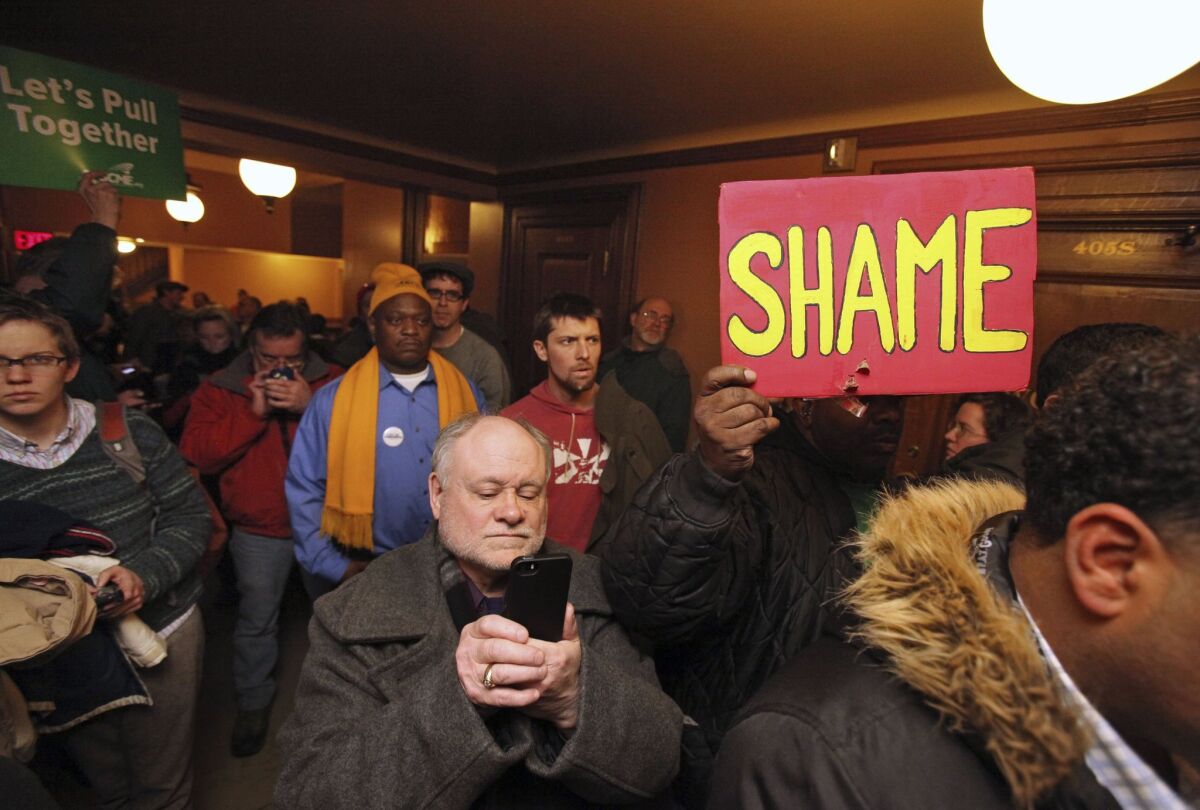 A crowd protests outside the doors of a hearing that was cut short for a right-to-work bill at the Wisconsin Capitol in Madison.