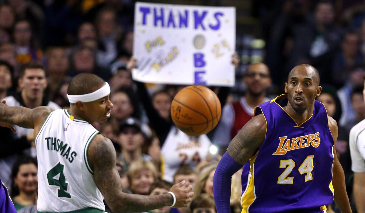 Los Angeles Lakers' Kobe Bryant and Boston Celtics' Isaiah Thomas eye a loose ball during the second half of the Lakers' 112-104 win on Wednesday.