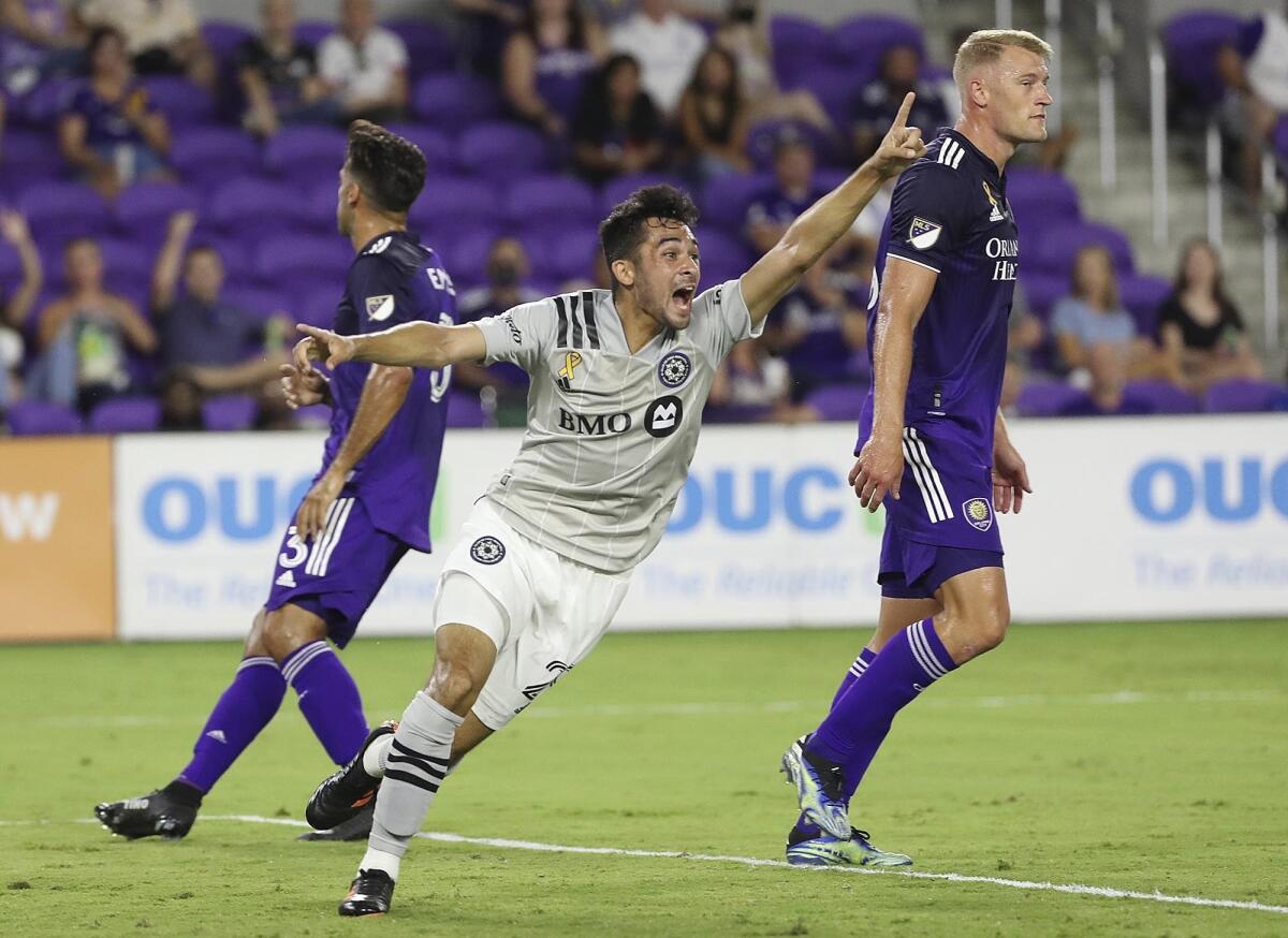 CF Montreal's Mathieu Choiniere shouts in celebration between Orlando City's Emmanuel Mas (3) and Robin Jansson (right) after Choiniere scored a goal during an MLS soccer match in Orlando, Fla., Wednesday, Sept. 15, 2021. (Stephen M. Dowell/Orlando Sentinel via AP)