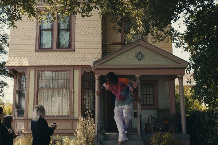 A 13-foot-tall Black man emerges from the front door of a Victorian house in a still from "I'm a Virgo."