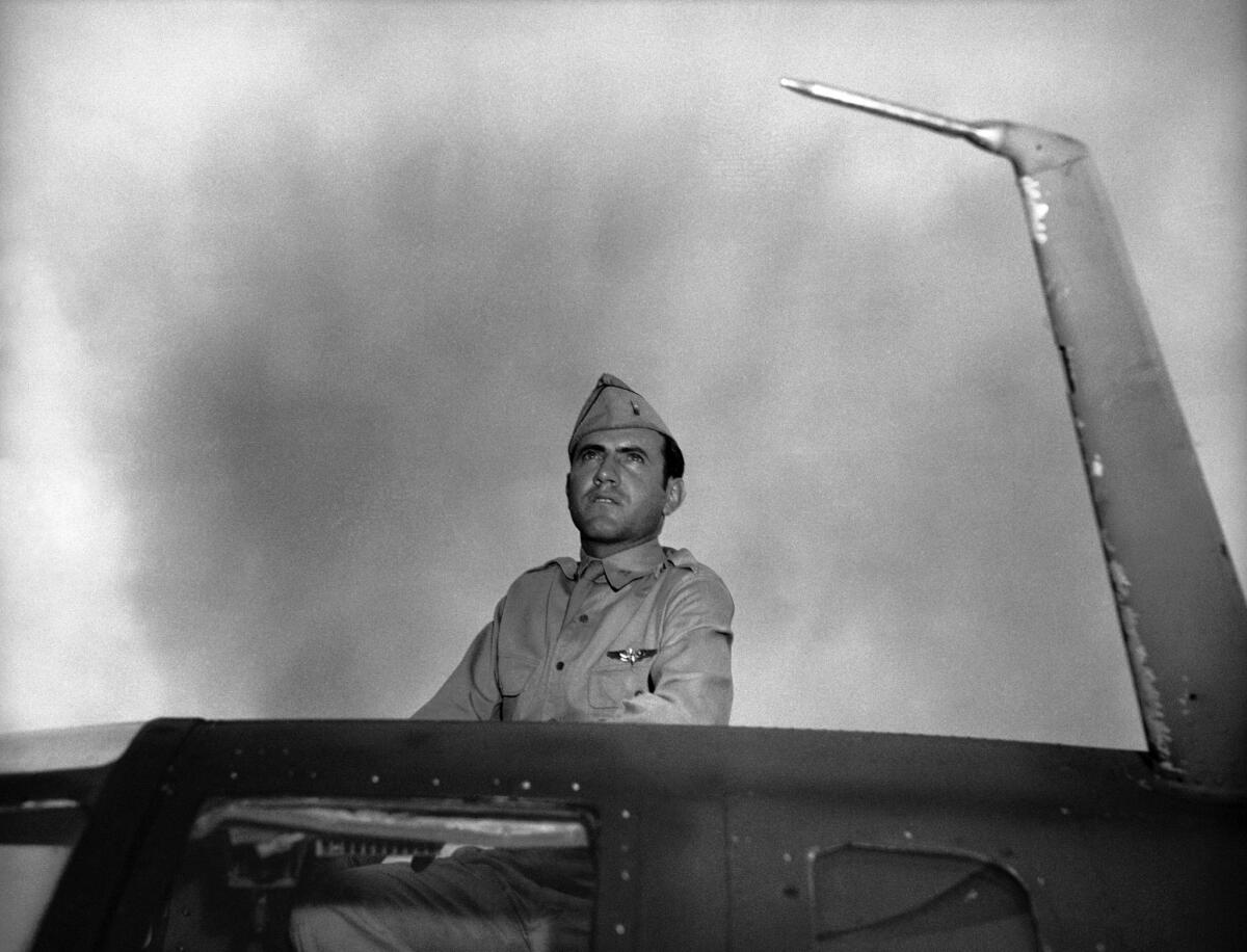 Louis Zamperini, then an Army Air Corps bombardier in World War II, looks out from the hatch of bomber in January 1943.