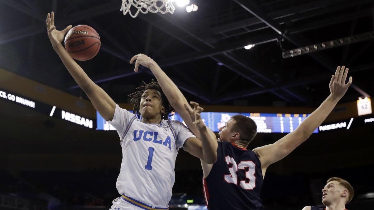 UCLA center Moses Brown, left, loses his grip on the ball as he is defended by Belmont center Nick Muszynski during the second half.