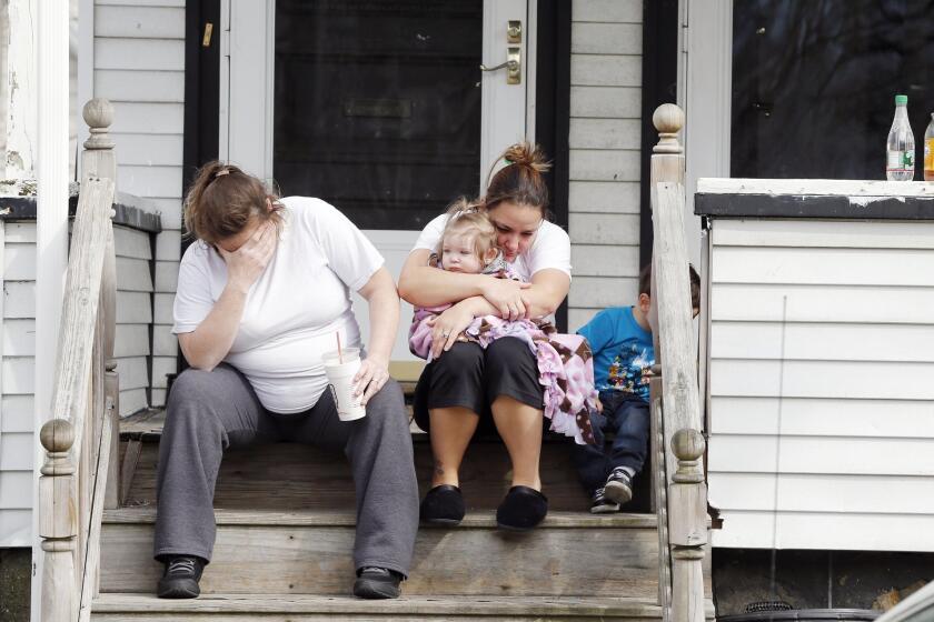 Grieving neighbors sit outside the house of Krystle Campbell's parents in Medford, Mass., on Tuesday. Campbell was killed in Monday's explosions at the finish line of the Boston Marathon.