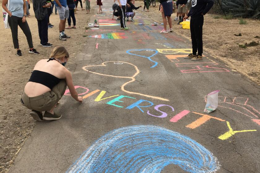 Local residents add chalk drawings to the La Jolla Bike Path in support of the Black Lives Matter movement Sept. 27.