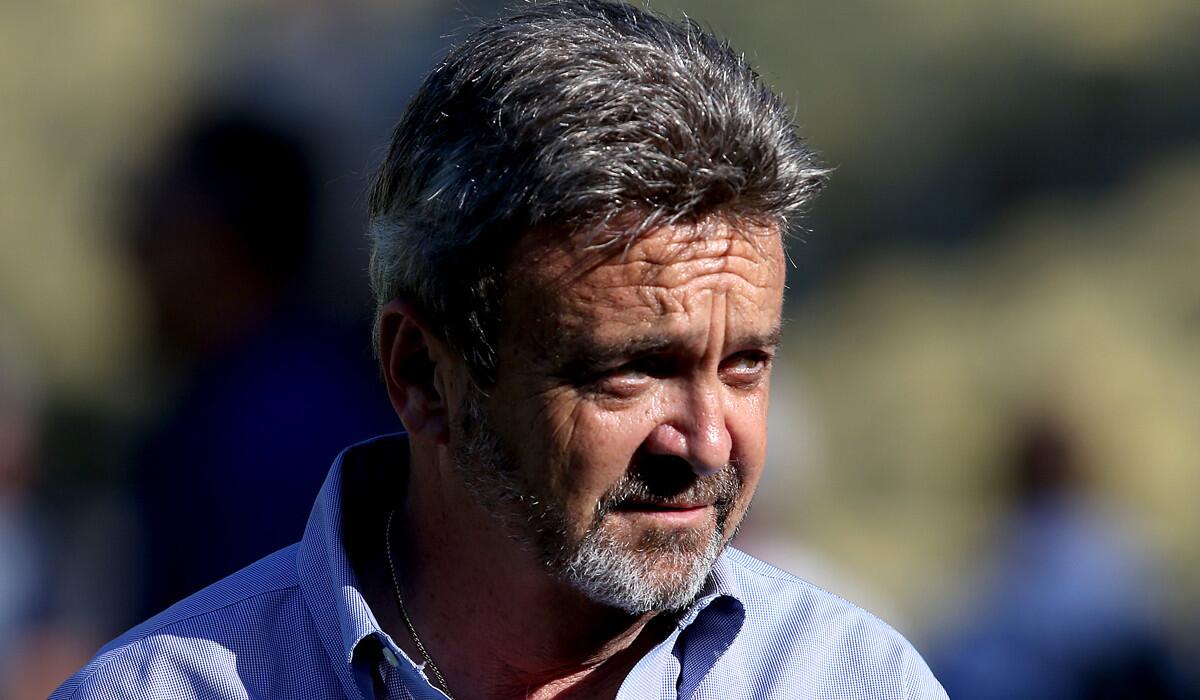 Former GM Ned Colletti watches the Dodgers warmup for a game against the Cardinals this summer.