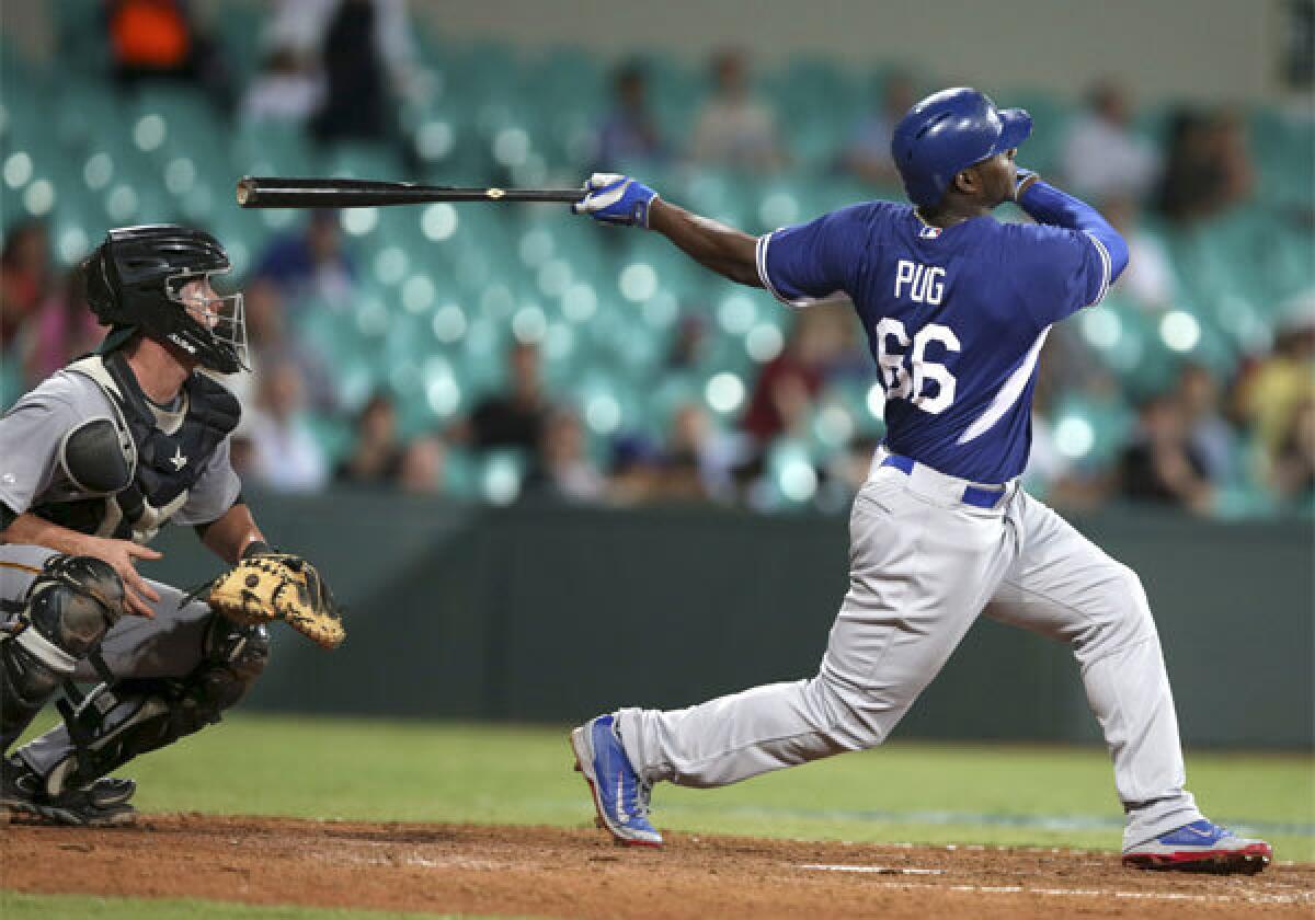 Yasiel Puig hits a two-run home run for the Dodgers during the eighth inning of their exhibition game Thursday against Team Australia at the Sydney Cricket Ground.