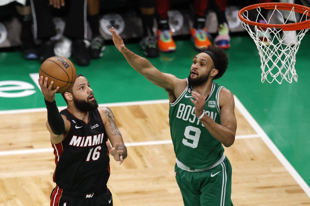 Miami Heat forward Caleb Martin shoots as Boston Celtics guard Derrick White defends.