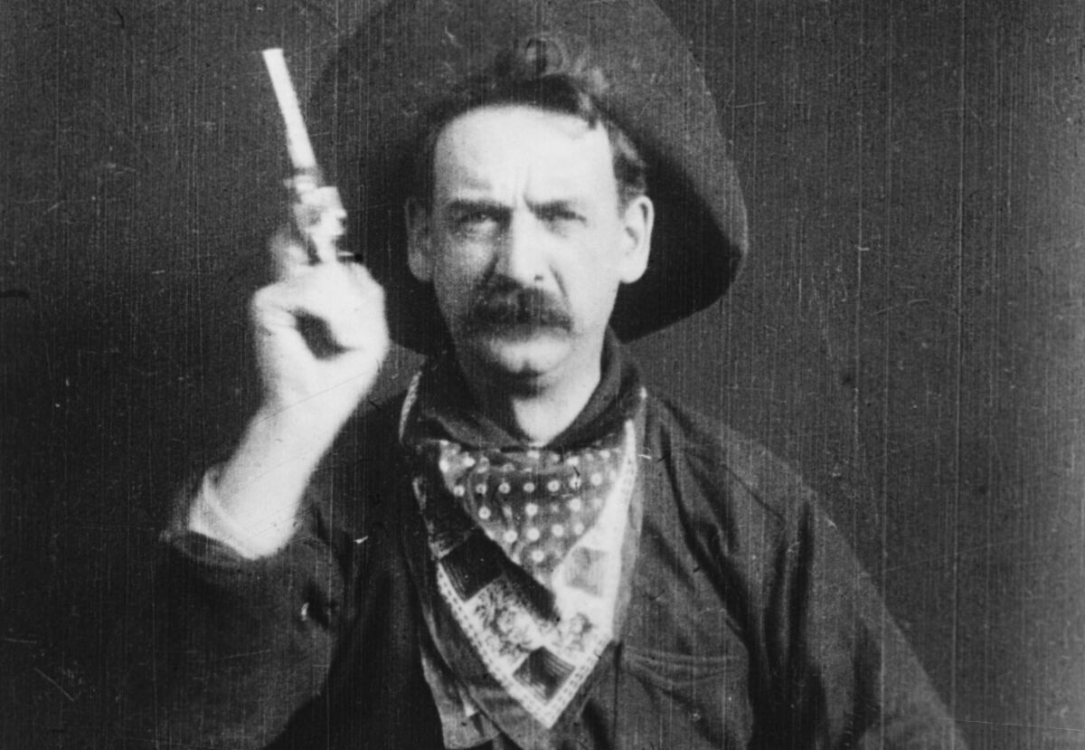 A bandit, played by George Barnes, prepares to shoot his gun at the camera in a scene from "The Great Train Robbery."