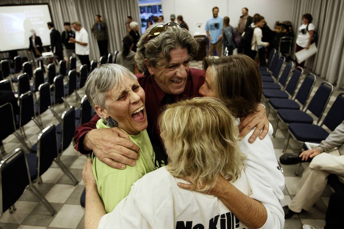 Hunter Kilpatrick, center, of the California Gray Whale Coalition celebrates with Molly Johnson, left, Mandy Davis, right, and Marla Jo Bruton after the California Coastal Commission denied PG&E; a permit for offshore seismic tests.