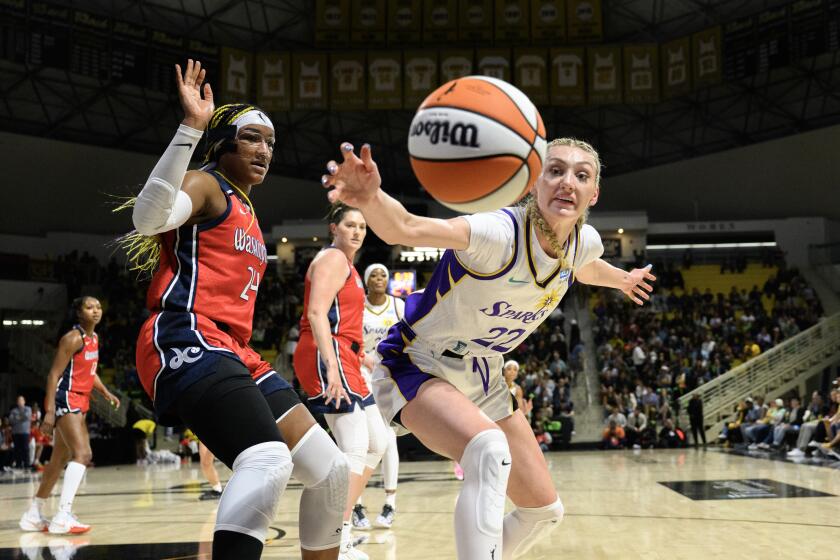 LONG BEACH, CA - MAY 21, 2024: Los Angeles Sparks forward Cameron Brink (22) lunges for a loose ball against Washington Mystics forward Aaliyah Edwards (24) in the first half at Walter Pyramid at Long Beach State on May 21, 2024 in Long Beach, California. (Gina Ferazzi / Los Angeles Times)