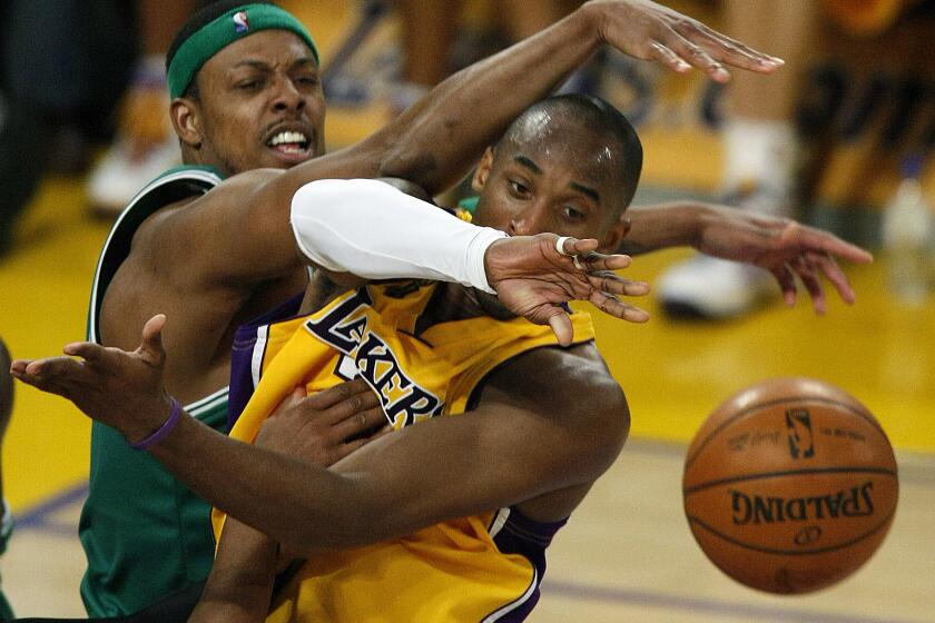 LOS ANGELES, CA - JUNE 12, 2008 Lakers Kobe Bryant passes the ball as he is attacked by the Boston Celtics Paul Pierce in the second quarter in game four of the NBA Finals Thursday, June 12, 2008 at Staples Center.(Rob Gauthier/Los Angeles Times)