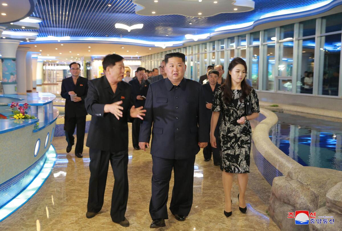 In an undated photo provided Saturday by the North Korean government, North Korean leader Kim Jong Un, center, and his wife, Ri Sol Ju, inspect a newly opened seafood restaurant in Pyongyang.