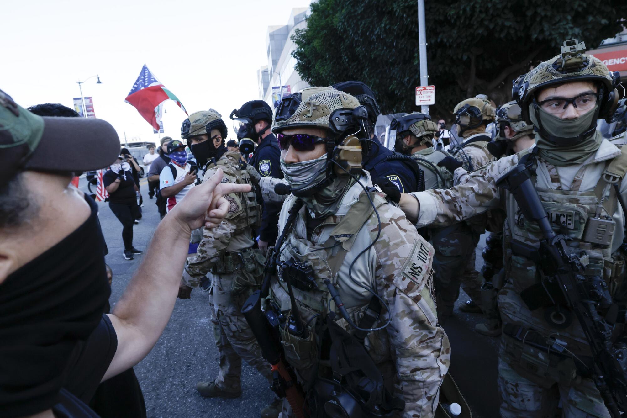 US Customs and Border Protection officers and DHS police push back protesters as they rally against the ongoing ICE raids.