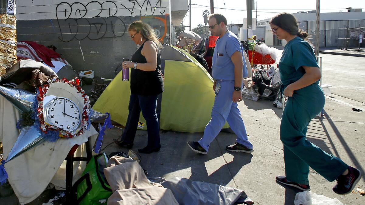 Dr. Susan Partovi leads Dr. Andrew Frerking and Dr. Lisa Altieri through skid row.