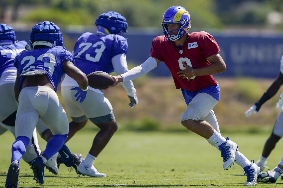Rams quarterback Matthew Stafford (9) hands the ball to Kyren Williams (23) during a joint practice with the Raiders.
