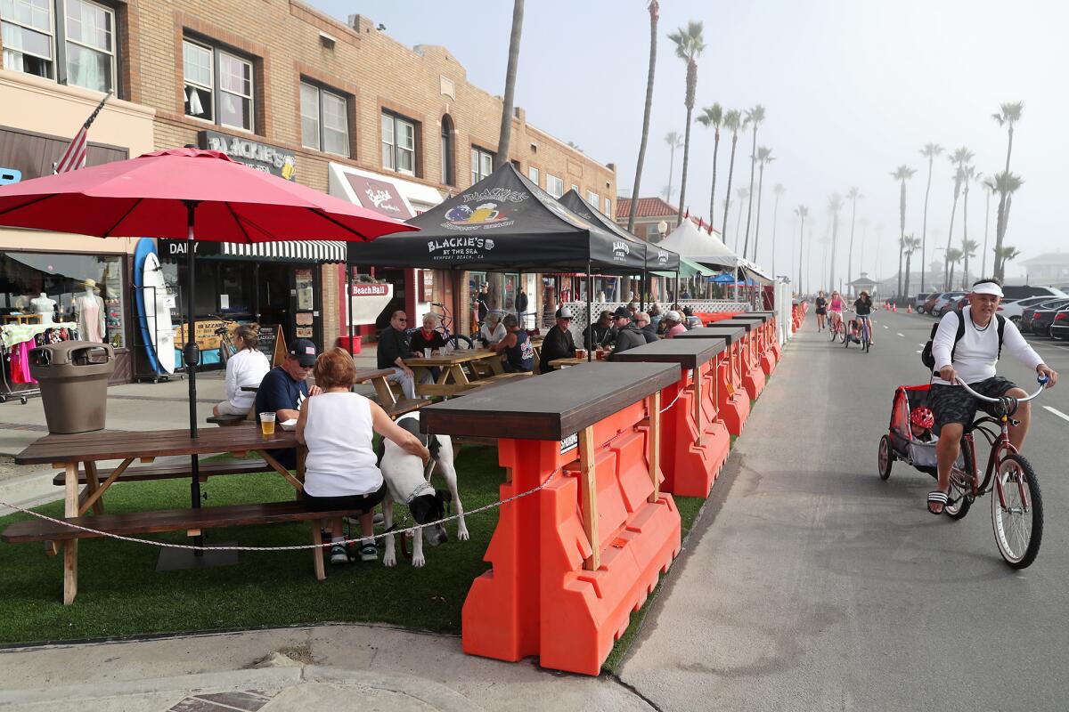 Customers sit in an outdoor dining area near Blackie's By the Sea at Newport Beach Pier.