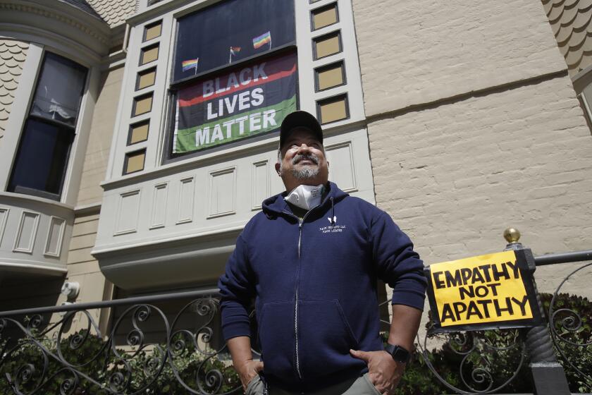 James Juanillo poses outside of his home in San Francisco, Sunday, June 14, 2020. The CEO of a cosmetic company issued an apology Sunday after she and her husband confronted Juanillo and threatened to call police because he stenciled "Black Lives Matter" in chalk on his San Francisco property, as the couple asserted that they know Juanillo doesn’t live there and is therefore breaking the law. (AP Photo/Jeff Chiu)