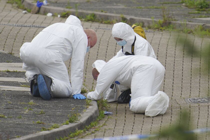 Forensic officers work in Biddick Drive in the Keyham area of Plymouth, England Friday Aug. 13, 2021 where six people were killed in a shooting incident. Police in southwest England say several people were killed, including the suspected shooter, in the city of Plymouth in a “serious firearms incident” that wasn’t terror-related. (Ben Birchall/PA via AP)