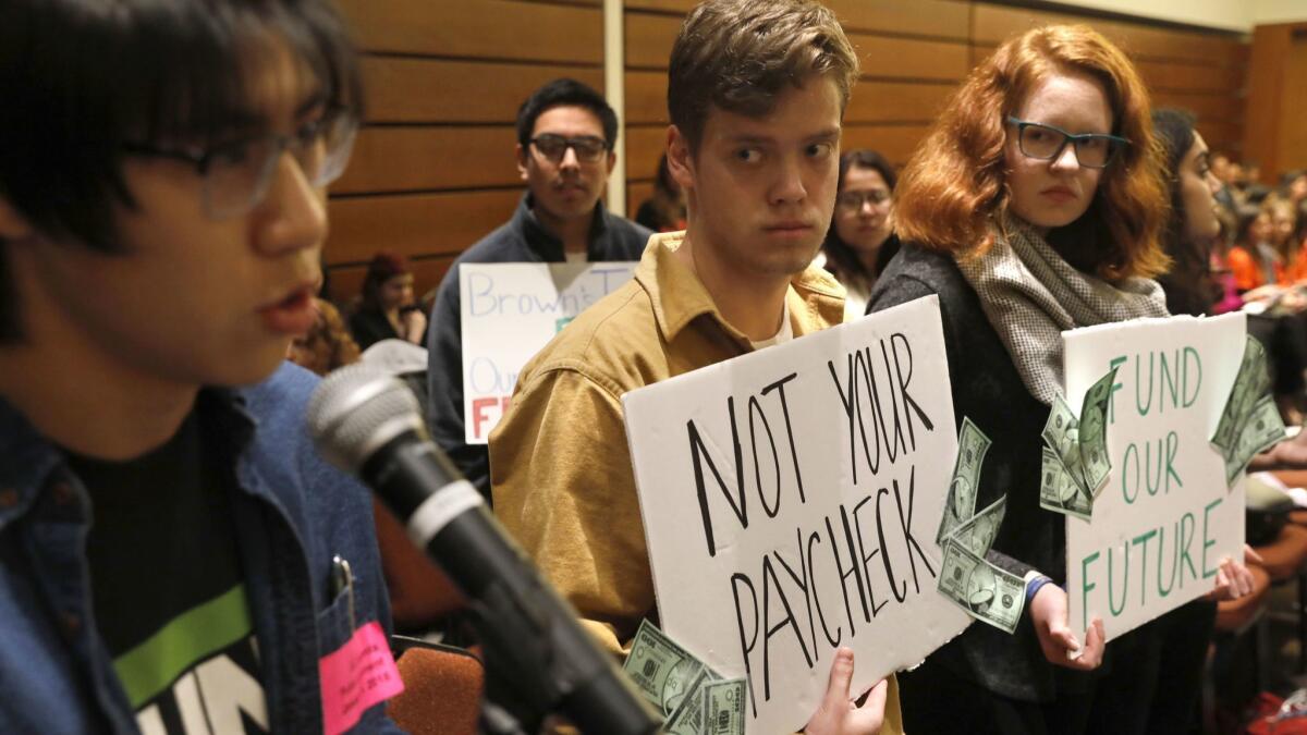 The UC regents plan to vote on an $8.7-billion spending plan for 2018-19 that includes the first tuition decrease in nearly 20 years. Above, UC Berkeley student Calvin Nguyen, left, speaks out against tuition hikes at a UC Board of Regents meeting.